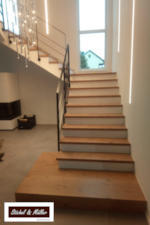Holz-Treppe - Stufen Ast-Eiche-Furnier weiß gebeizt - Setzstufen weiß - Edelstahlgeländer anthrazit - Ansicht Aufgang